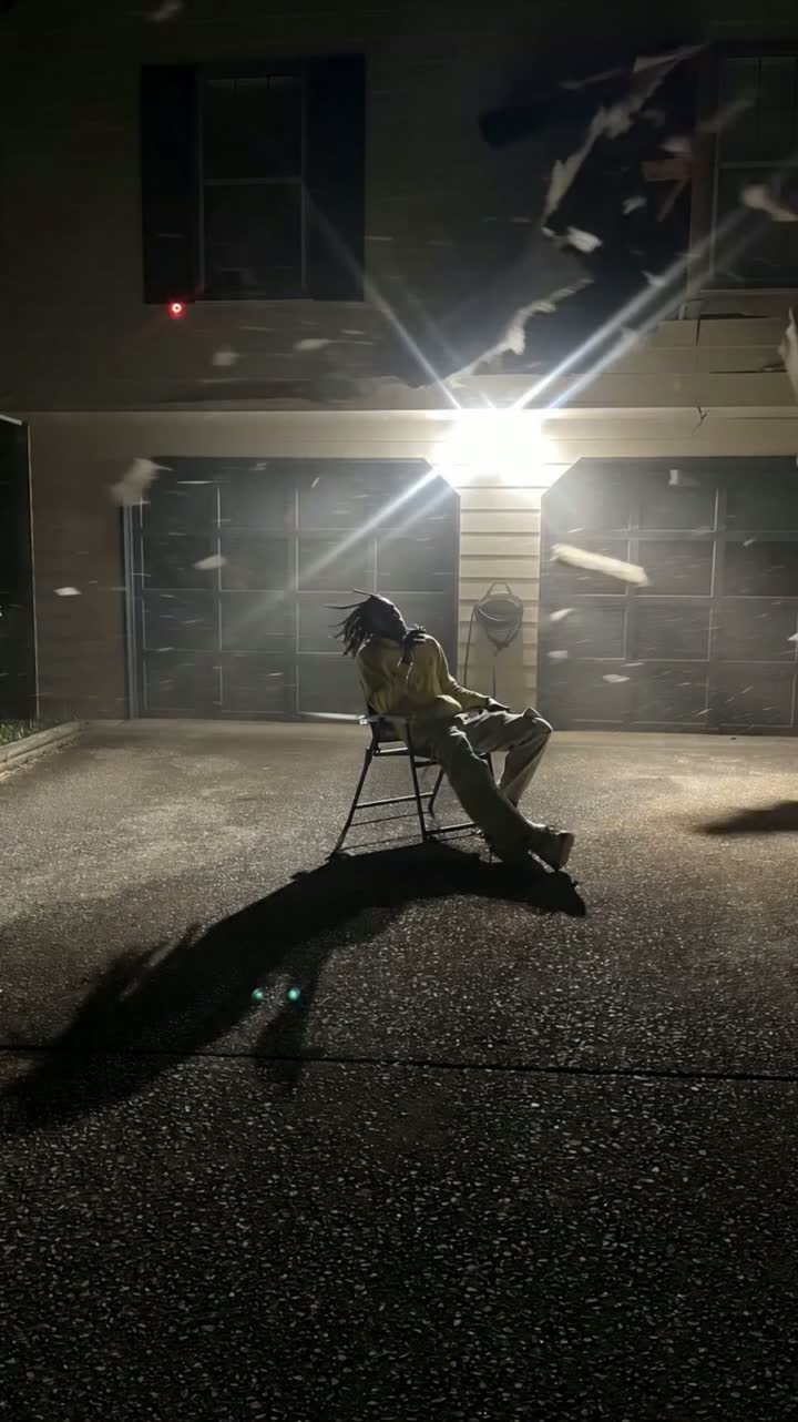A cinematic practical-effects scene with a seated subject